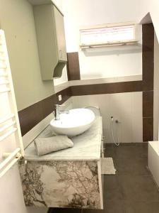 ein Badezimmer mit weißem Waschbecken und Fenster in der Unterkunft LaMaison Ayem Zmen S3 in El Haouach