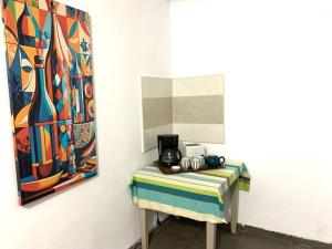 ein Tisch mit Kaffeemaschine neben einem Gemälde in der Unterkunft LaMaison Ayem Zmen S3 in El Haouach + 4 Fotos
