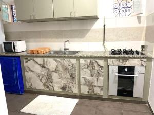 eine Küchentheke mit einer Spüle und einem Herd in der Unterkunft LaMaison Ayem Zmen S3 in El Haouach