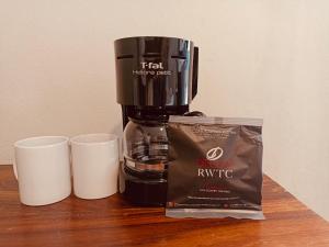 a coffee maker and two cups on a table at Suites 15 Avenida in Tapachula