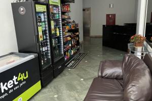 a vending machine in a store with a couch next to it at Varanda, TV 50, elevador, no Centro, garagem paga in Viçosa
