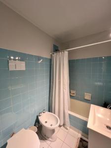 un bagno blu con un water e un lavandino di Apartamento Torreón Cerca del mar y Güemes a Mar del Plata