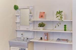 a bathroom with white shelves with a sink and a mirror at Kaikai House - Art, Design & Family in Shibuya in Tokyo +70 photos