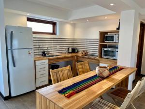a kitchen with a wooden table and a refrigerator at Haven Patagonia in El Calafate