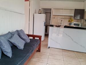 a living room with a couch and a white refrigerator at Casita en Florida in Florida