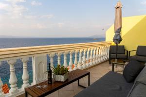 a balcony with a couch and an umbrella and the ocean at Apartments by the sea Prigradica, Korcula - 544 in Blato