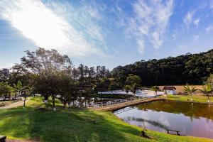 eine Brücke über einen Teich in einem Park in der Unterkunft Recanto das Águas - Chalés no meio da Mata Atlântica in Eldorado
