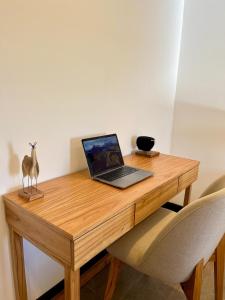 a laptop computer sitting on top of a wooden desk at Haven Patagonia in El Calafate +4 photos