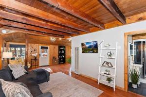 ein Wohnzimmer mit einem Sofa und Holzdecken in der Unterkunft NEW Cozy Coy Cabin with Hot Tub & AC in Big Bear City