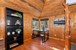 ein Holzzimmer mit einem Tisch und einem Baum in der Unterkunft NEW Cozy Coy Cabin with Hot Tub & AC in Big Bear City