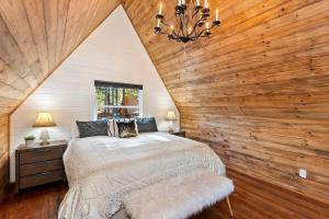 ein Schlafzimmer mit einem Bett und einer Holzwand in der Unterkunft NEW Cozy Coy Cabin with Hot Tub & AC in Big Bear City