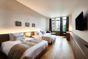 京都市にあるTHE GATE HOTEL京都高瀬川 by HULICのベッド2台と薄型テレビ付きのホテルの部屋