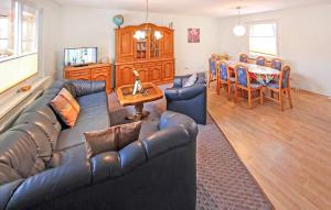 Una sala de estar con un sofá de cuero y una mesa. en Ferienhaus Trassenheide, en Trassenheide