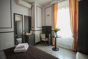 Habitación con escritorio y ventana con mesa. en Royal Suite du Vatican, en Roma