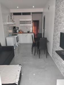 a kitchen and living room with a table and chairs at Apartamento em Pedra Badejo in Pedra Badejo +4 photos