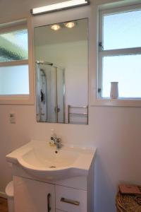 un bagno con lavandino e specchio di LAST ON THE STRAND, RUSSELL - The BOATHOUSE a Russell