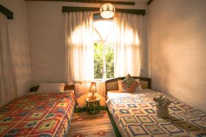 due letti in una stanza con finestra di Peace Eye Guest House a Pokhara