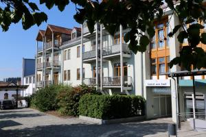 ein Apartmenthaus mit Balkon auf einer Straße in der Unterkunft Hotel am Hof in Taufkirchen
