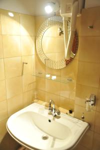 a bathroom with a sink and a mirror at Polyxeni Hotel in Pythagoreio