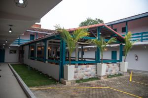 a building with palm trees in a parking lot at Hotel Praia do Morro in Guarapari