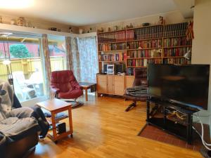 a living room with a television and bookshelves at Teglverket in Trondheim