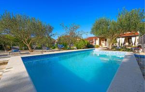 a swimming pool with blue water in a yard at One-Bedroom Holiday Home In Konjevrate in Konjevrate