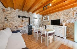 a living room with a table and a stove at One-Bedroom Holiday Home In Konjevrate in Konjevrate