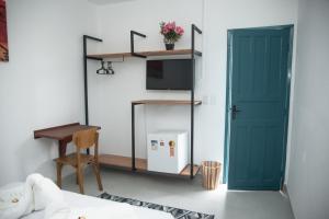 a room with a green door and a desk at Hotel Praia do Morro in Guarapari