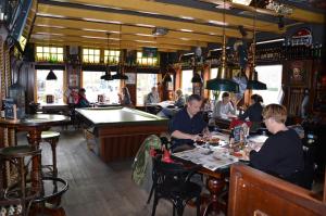 a group of people sitting at a bar with a pool table at HCR Teernstra in Balk