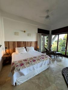 a bedroom with a large bed and a piano at Vista para o Mar - Studio com 2 banheiros - Barra do Sahy in São Sebastião