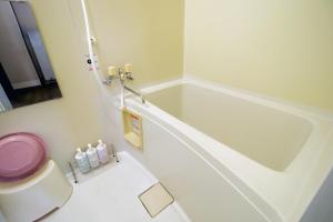 een witte badkamer met een bad en een toilet bij Yadokito2 in Otaru