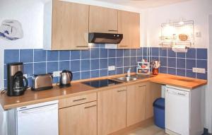 una cocina con armarios de madera y azulejos azules en la pared en Ferienwohnung Pruchten, en Pruchten