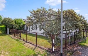 a fence with a tree in front of a house at Ferienhaus Gahlkow in Gahlkow +10 photos