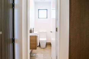 Un baño con inodoro blanco y ventana. en The Best Value 2-bedroom Brand-new built townhouse, en Wanaka 9 fotos más