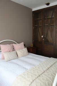 a bedroom with a white bed with a wooden door at Casa La Peguera in La Parra +32 photos