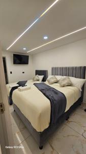 a bedroom with two beds and a tv on the wall at Hotel West Inn in Bogotá