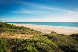 a sandy beach with people walking on the beach at Royal Hideaway Sancti Petri in Chiclana de la Frontera