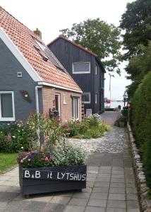 uma casa com um sinal que diz batom bb h em B&B It Lytshûs em Earnewâld