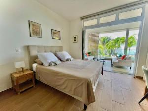 PaeaTahatai - Private beach, pool, AC, High speed net的一间带大床的卧室和一间客厅