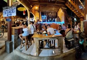 a group of people sitting at tables in a restaurant at Fantastic B"n"B in Gili Islands