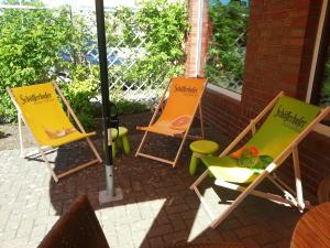 un grupo de sillas sentadas en un patio en Café Pension Steffen, en Sanitz