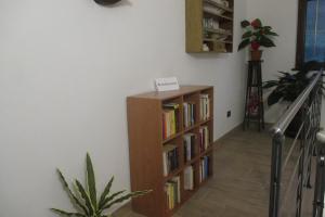 a book shelf with books on it next to a staircase at Agriturismo A' Taversa in Levanto