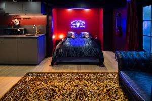 a bedroom with a bed with a red wall at Le studio rock in Orthez