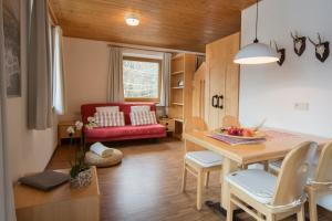 salon ze stołem i czerwoną kanapą w obiekcie Residence Veider w mieście Rasun di Sotto