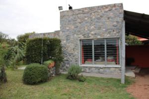 a stone house with a window in a yard at Etulia in Cuchilla Alta +4 photos