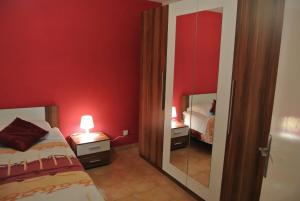 a red bedroom with two beds and a mirror at Apartments Priko in Stari Grad +35 photos