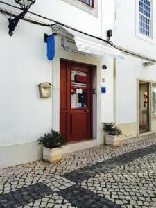 a red door on the side of a building at Alojamento Baixa Mar in Vila Real de Santo António