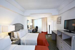um quarto de hotel com duas camas e uma televisão de ecrã plano em Mision Pachuca em Pachuca de Soto