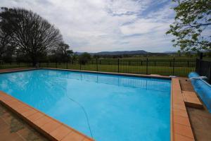 a large blue swimming pool with a fence at Redbank Estate - Luxury in Scone in Scone