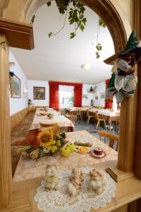 una sala de estar con dos mesas con comida. en Albergo GARNI' AURORA, en Tret